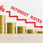 An illustration of stacked coins with a downward interest rate arrow, representing changes in interest-only loan repayments.