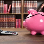 A piggy bank and calculator representing savings and loan planning.