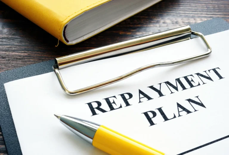Repayment plan document with pen on clipboard for lump sum planning