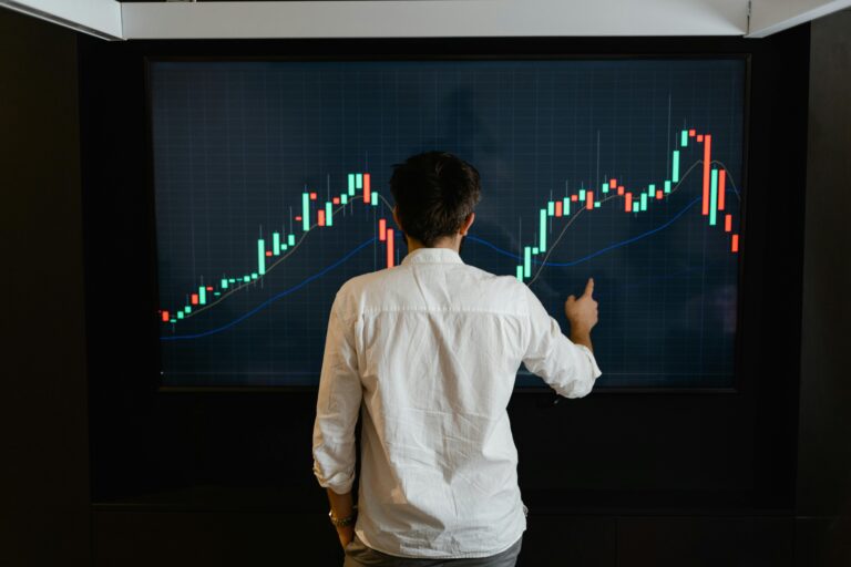 Man analyzing financial charts on a large screen, symbolizing the evaluation process of choosing an offset account for mortgage management.