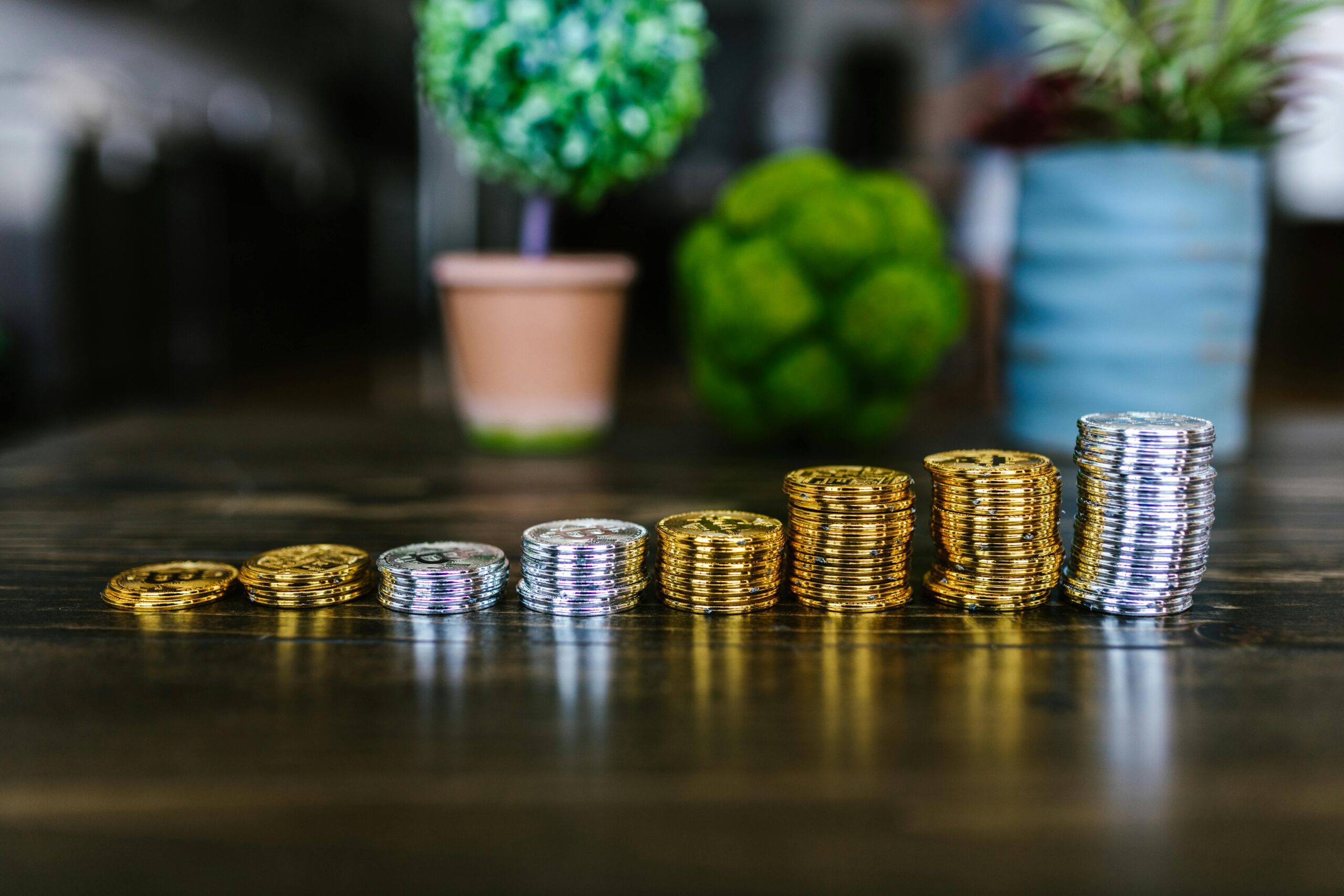 Stacks of gold and silver coins increasing in height, symbolizing growing savings through an offset account strategy.