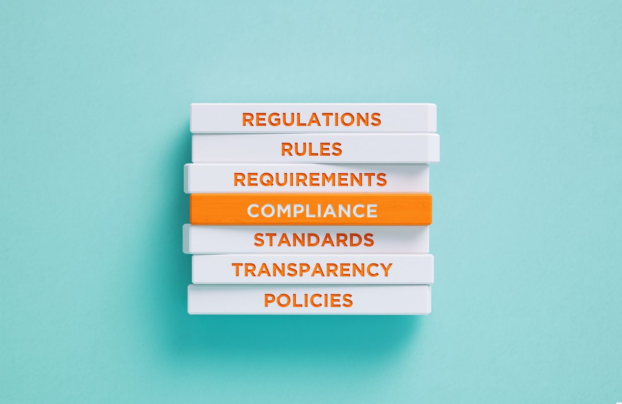Stacked blocks showing compliance, rules, and regulations.