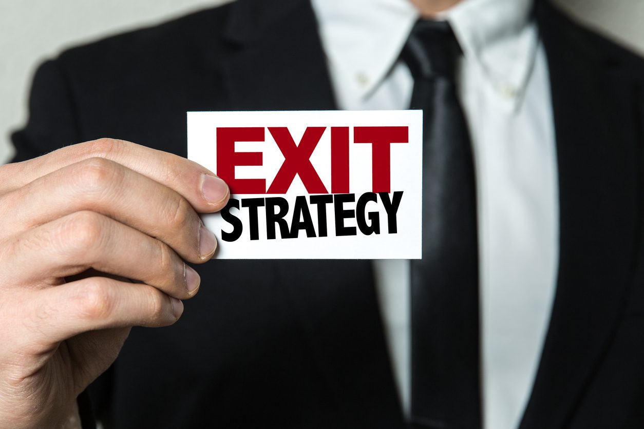 Businessman holding an 'Exit Strategy' sign.