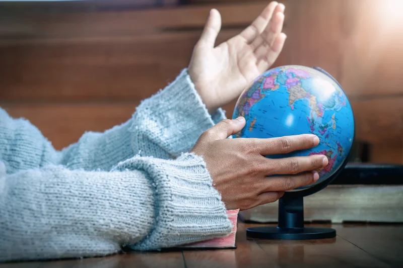 Person holding a globe representing Australian expats investing from abroad.