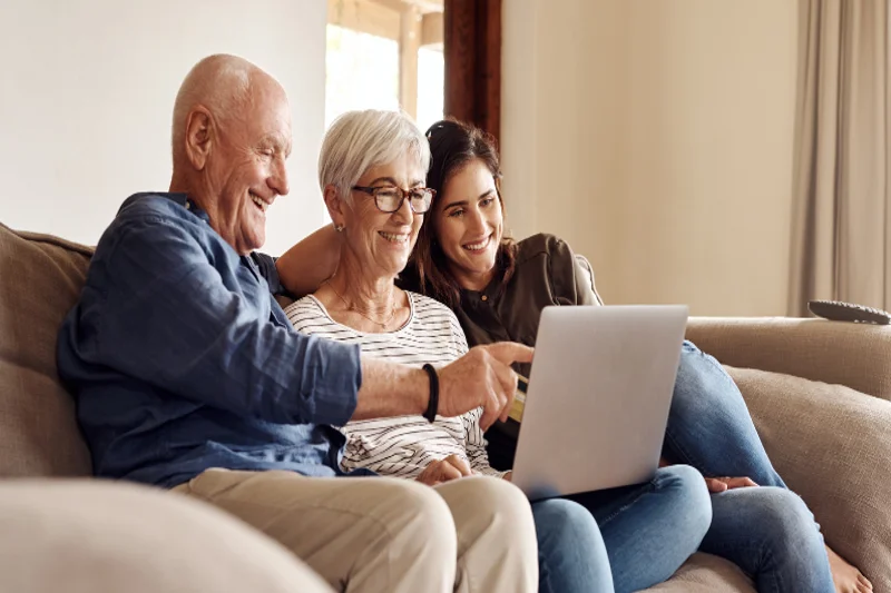 Parents assisting their child with a laptop, symbolizing family support for securing a loan.