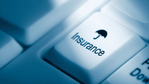 Computer keyboard key labeled “Insurance” with umbrella icon, symbolizing mortgage protection and LMI.