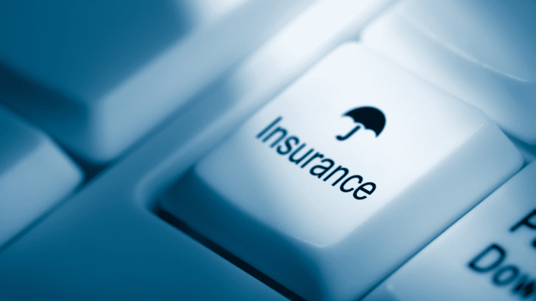 Computer keyboard key labeled “Insurance” with umbrella icon, symbolizing mortgage protection and LMI.