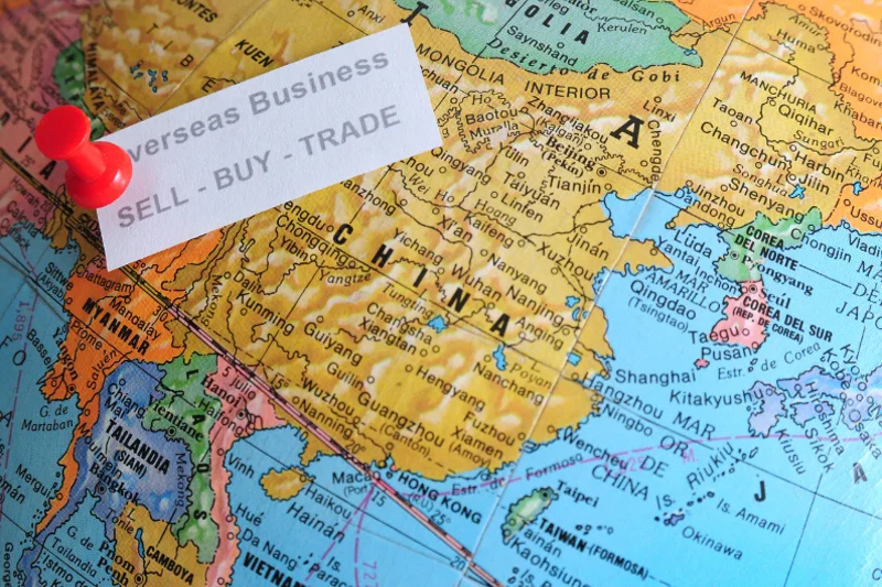 Globe marked with “Overseas Business” highlighting international property investment.