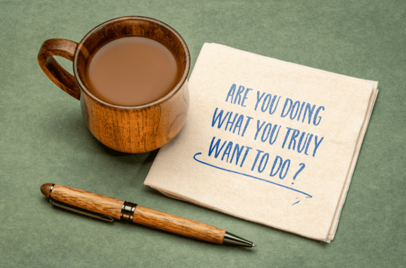 A cup of coffee next to a napkin with the handwritten question “Are you doing what you truly want to do?”—symbolising reflection and life choice decisions.