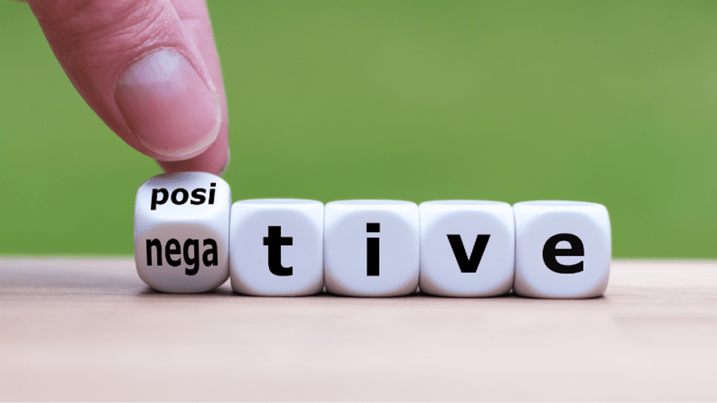 Dice spelling "negative" being turned to "positive" by a human hand