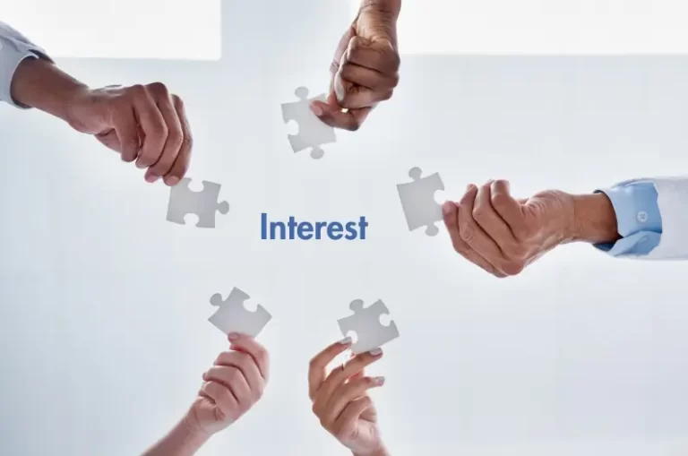 Hands holding puzzle pieces around the word “Interest”