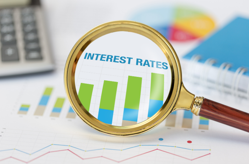 Magnifying glass focusing on bar graph labeled interest rates