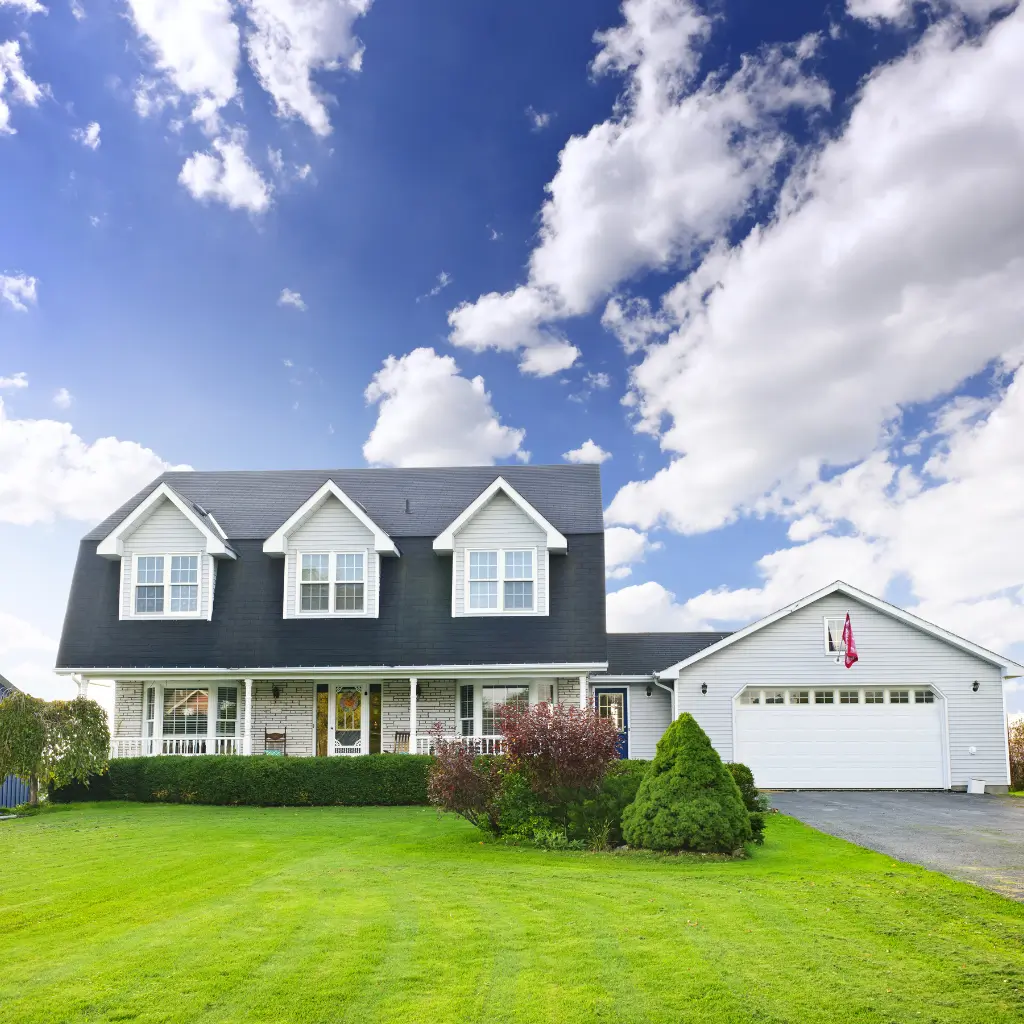 Large double-storey home on open green land under a bright blue sky in regional NSW.