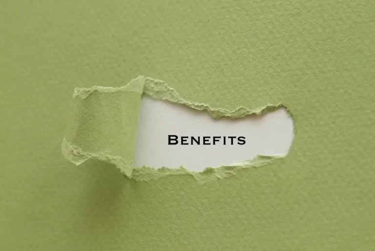Word 'Benefits' revealed through torn green paper background
