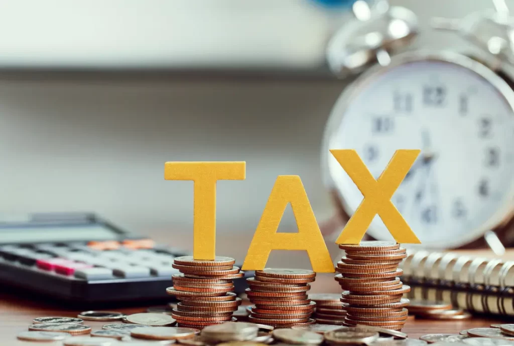 Stacked coins with TAX letters representing tax savings and planning