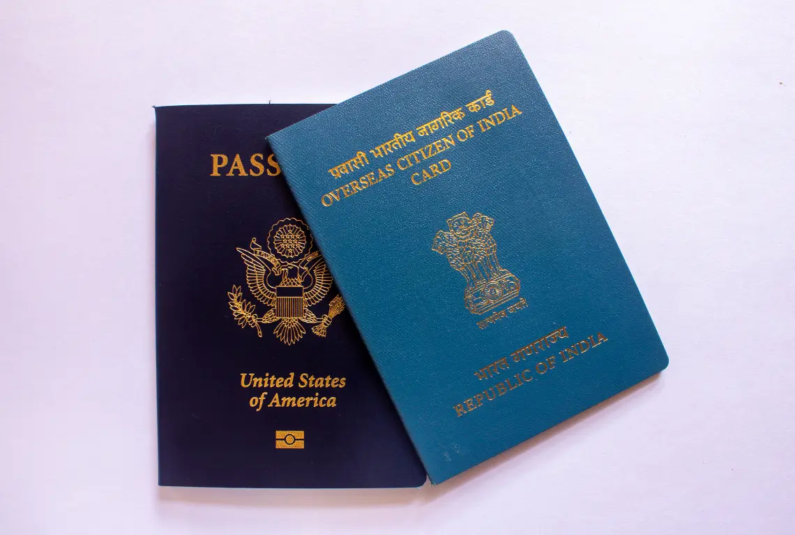 Two passports — a United States passport and an Overseas Citizen of India card — placed on a white background, representing non-resident visa documentation.