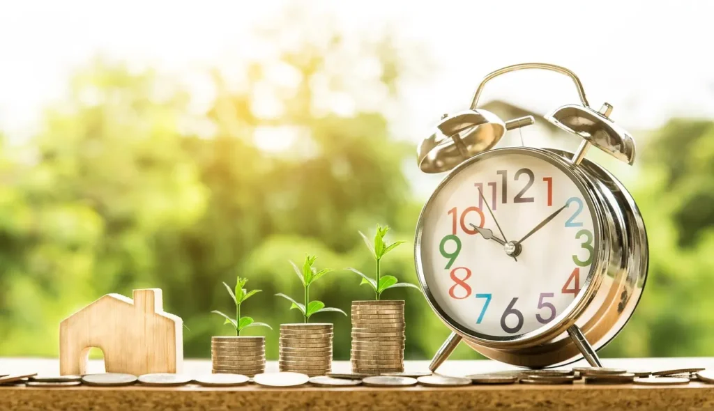 Home loan savings concept with house, coins and clock