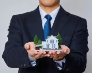 A professional mortgage broker holding a miniature house model in both hands, symbolising expert guidance and personalised home loan support.