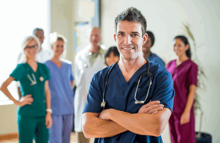 Smiling medical professionals standing together, with a doctor in scrubs at the front.