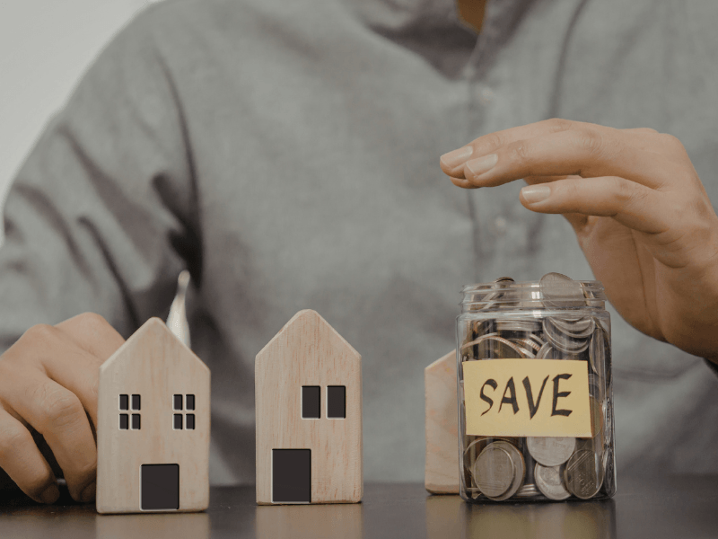 Saving money through home loan refinancing with coins and house models